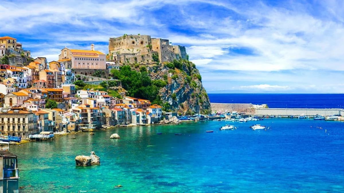 A Sicilian coastal town with a clifftop fortress above the harbour